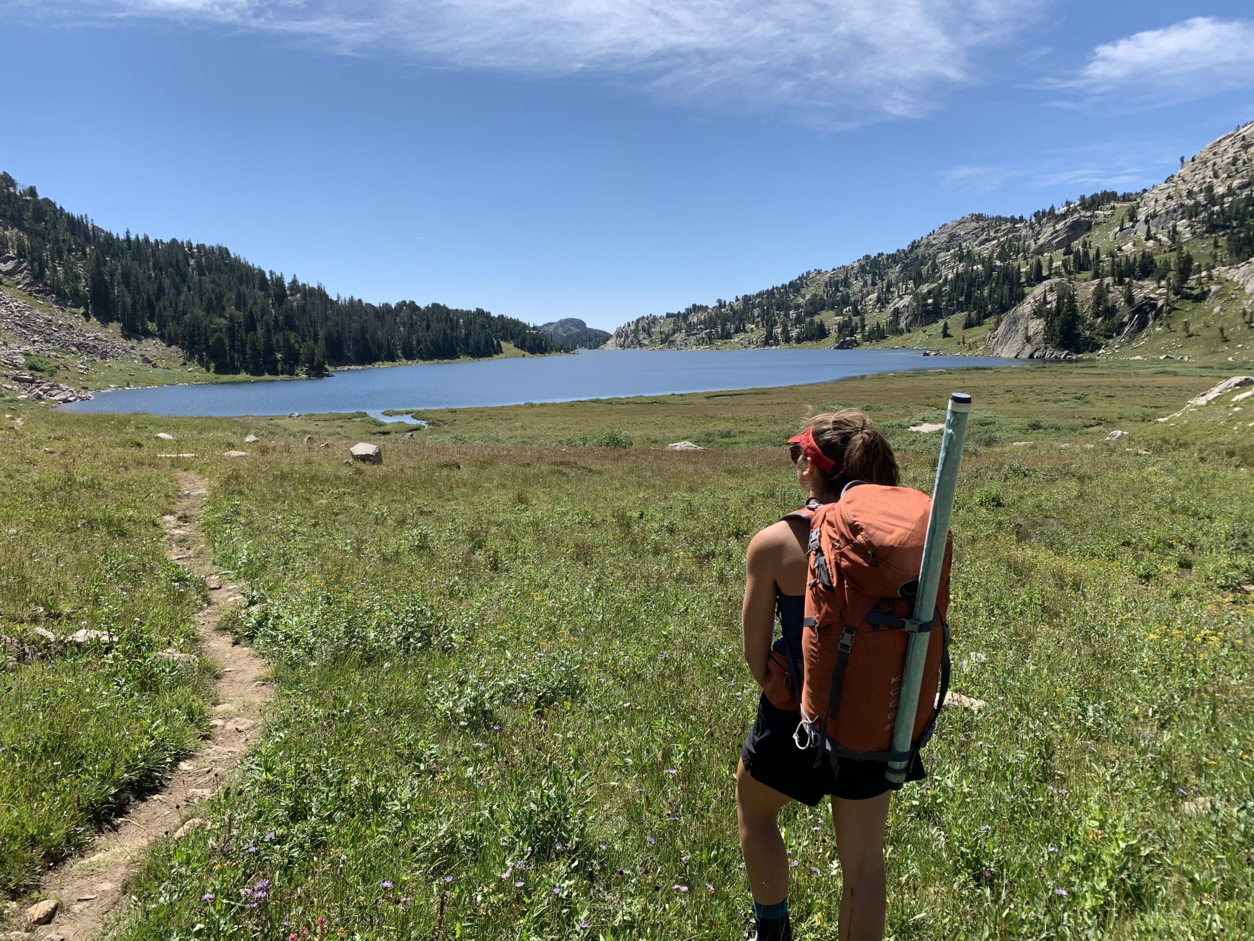Fisherman taking in the view of an alpine mountain lake